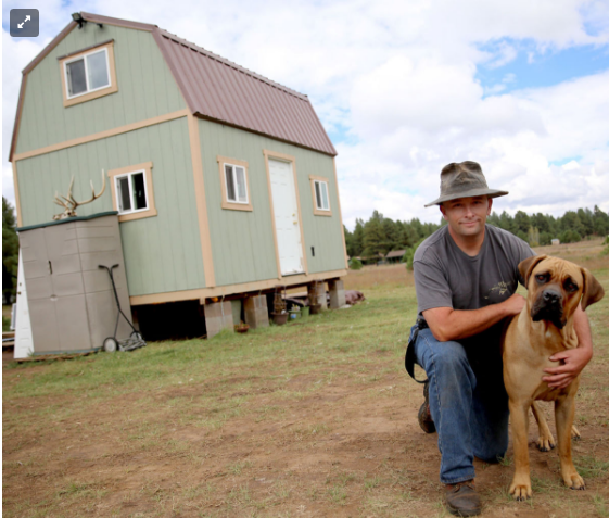 Collin Bass and his dog Lucca in front of their tiny house in Flagstaff, AZ.